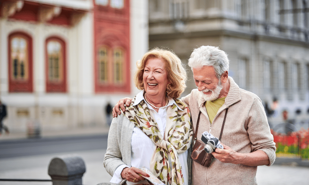 Senior couple enjoying their vacation on a guided bus tour from Edmonton, smiling and taking in the scenery.