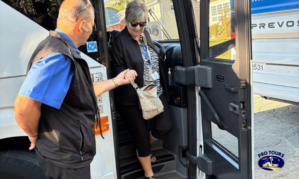 Tour director assisting a traveler exiting a Pro Tours motorcoach